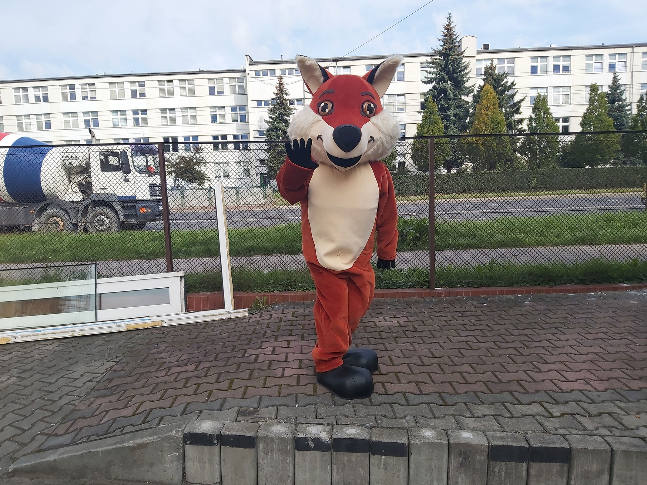 Na fotografii widnieje strój reklamowy w postaci lisa pozujący do zdjęcia na jednej z krakowskich ulic w pobliżu siedziby firmy Elabika